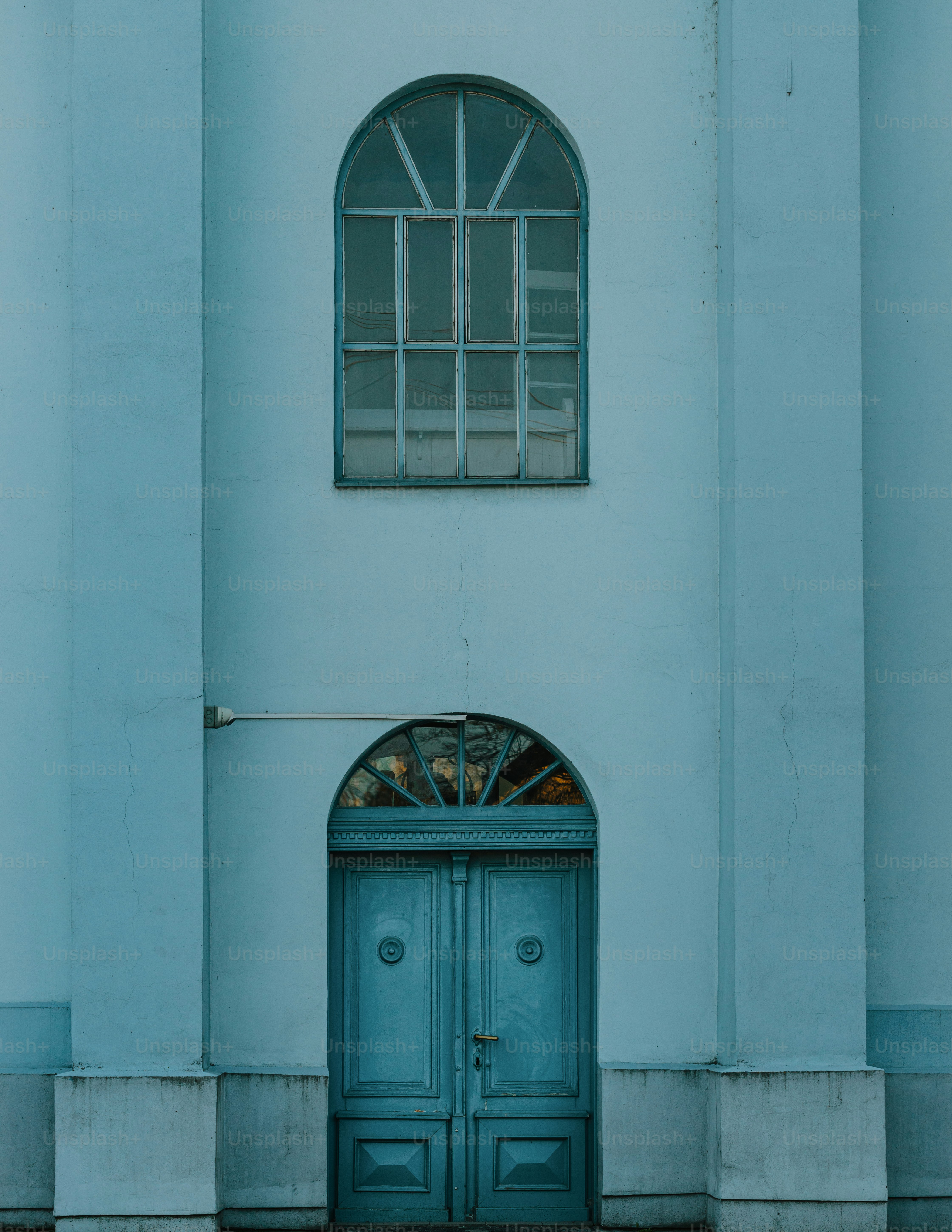a building with a blue door and arched window